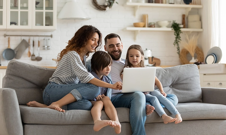 family on sofa with laptop