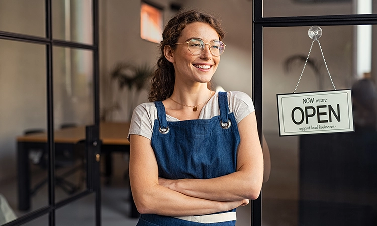 smilng woman business owner open sign